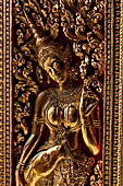 Wat Xieng Thong temple in Luang Prabang, Laos. Detail of the gilded wood carvings of the doors of the Royal Funerary carriage hall. 